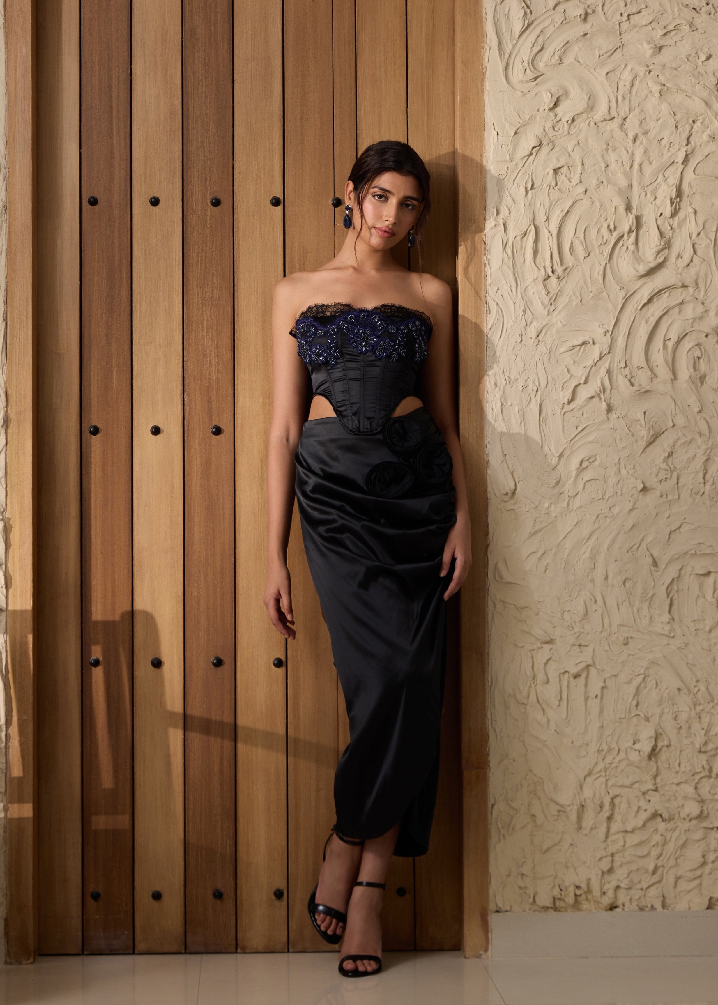 A black embellished corset paired with a matching skirt.