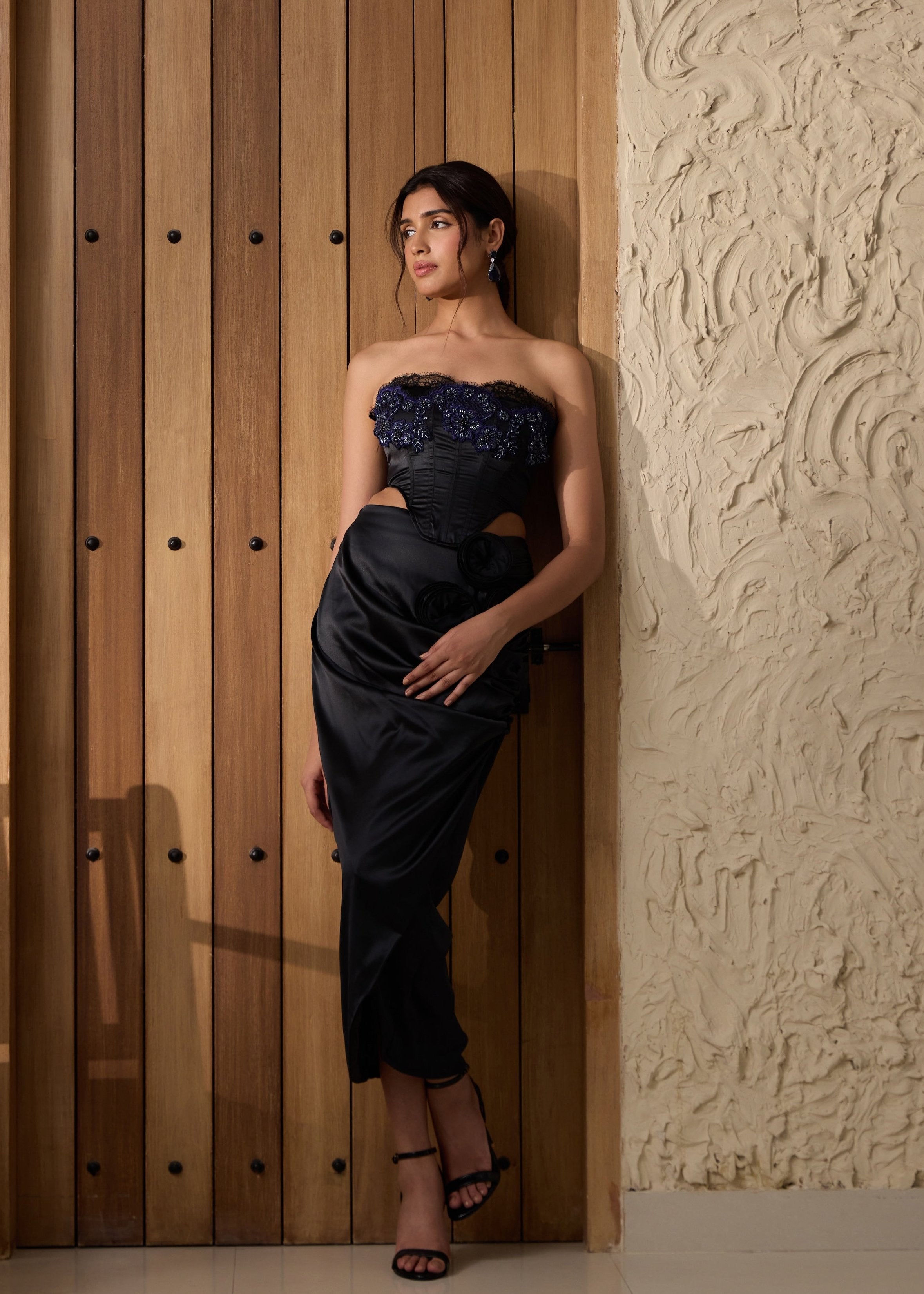 A black embellished corset paired with a matching skirt.