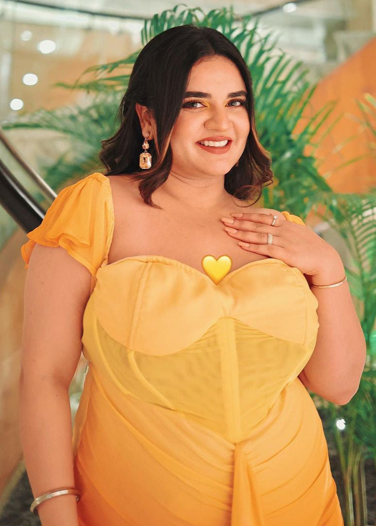 Chic woman in a Greta Sunset Ombre Chiffon Corset Dress, radiating a blend of vibrant colors and elegance