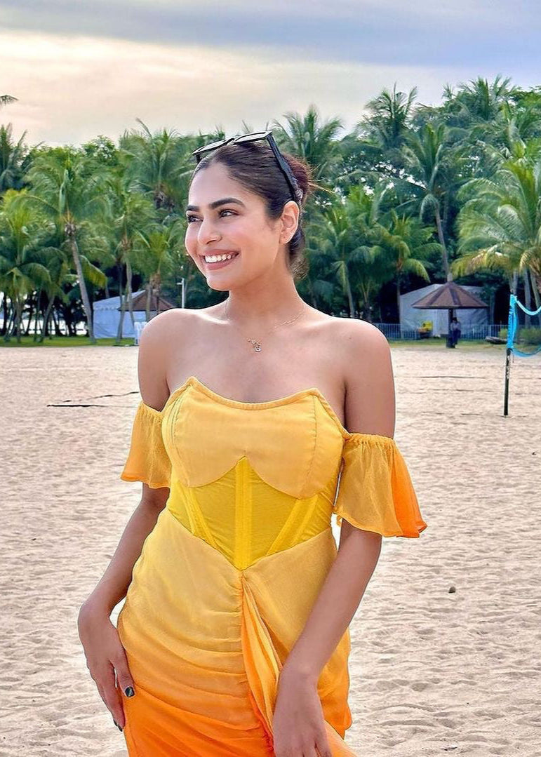 Chic woman in a Greta Sunset Ombre Chiffon Corset Dress, radiating a blend of vibrant colors and elegance