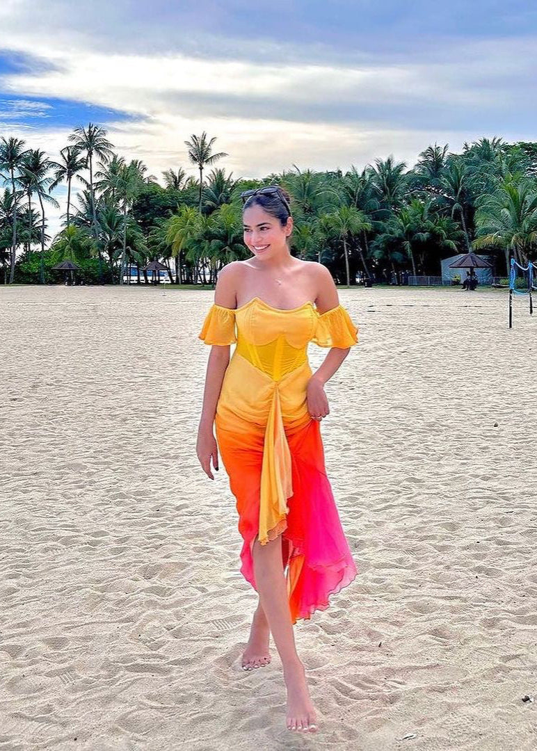 Chic woman in a Greta Sunset Ombre Chiffon Corset Dress, radiating a blend of vibrant colors and elegance