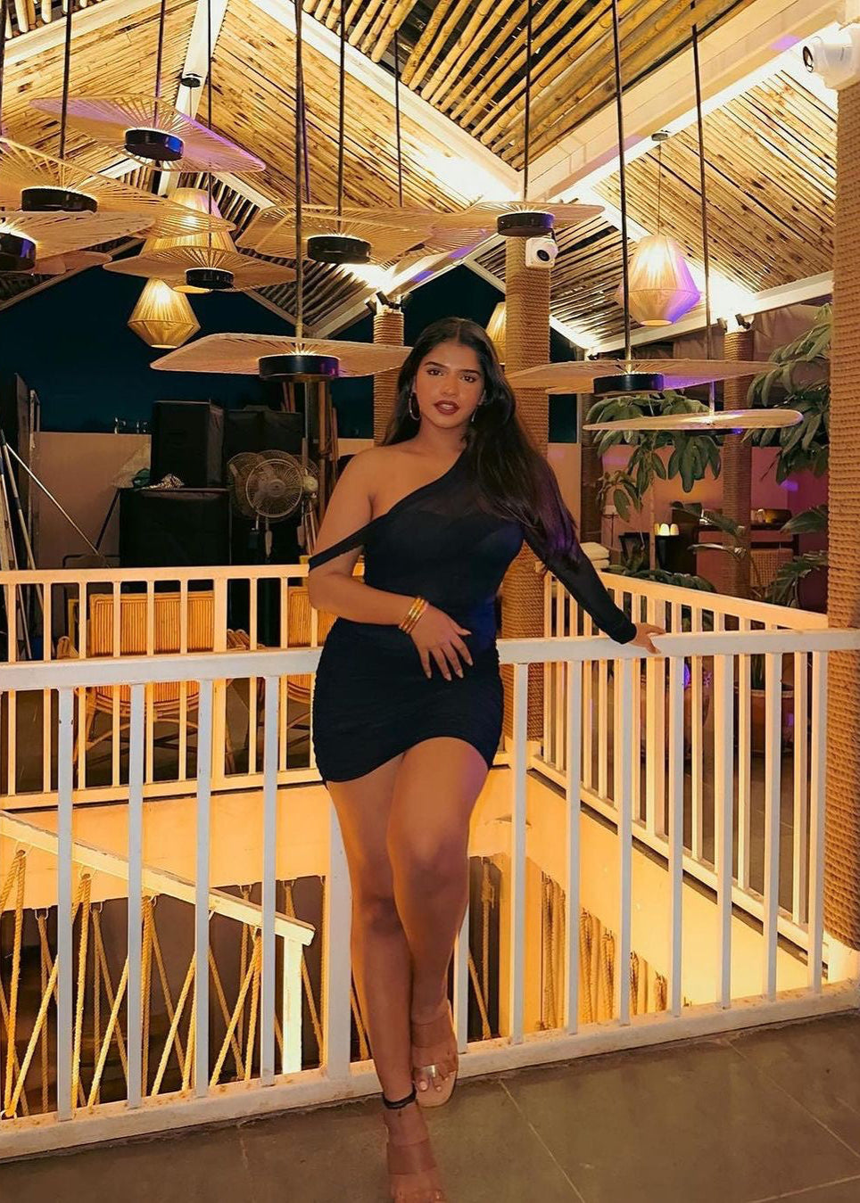 Stylish woman in a Gretchen Black Ruched Mesh Corset Dress, exuding modern sophistication