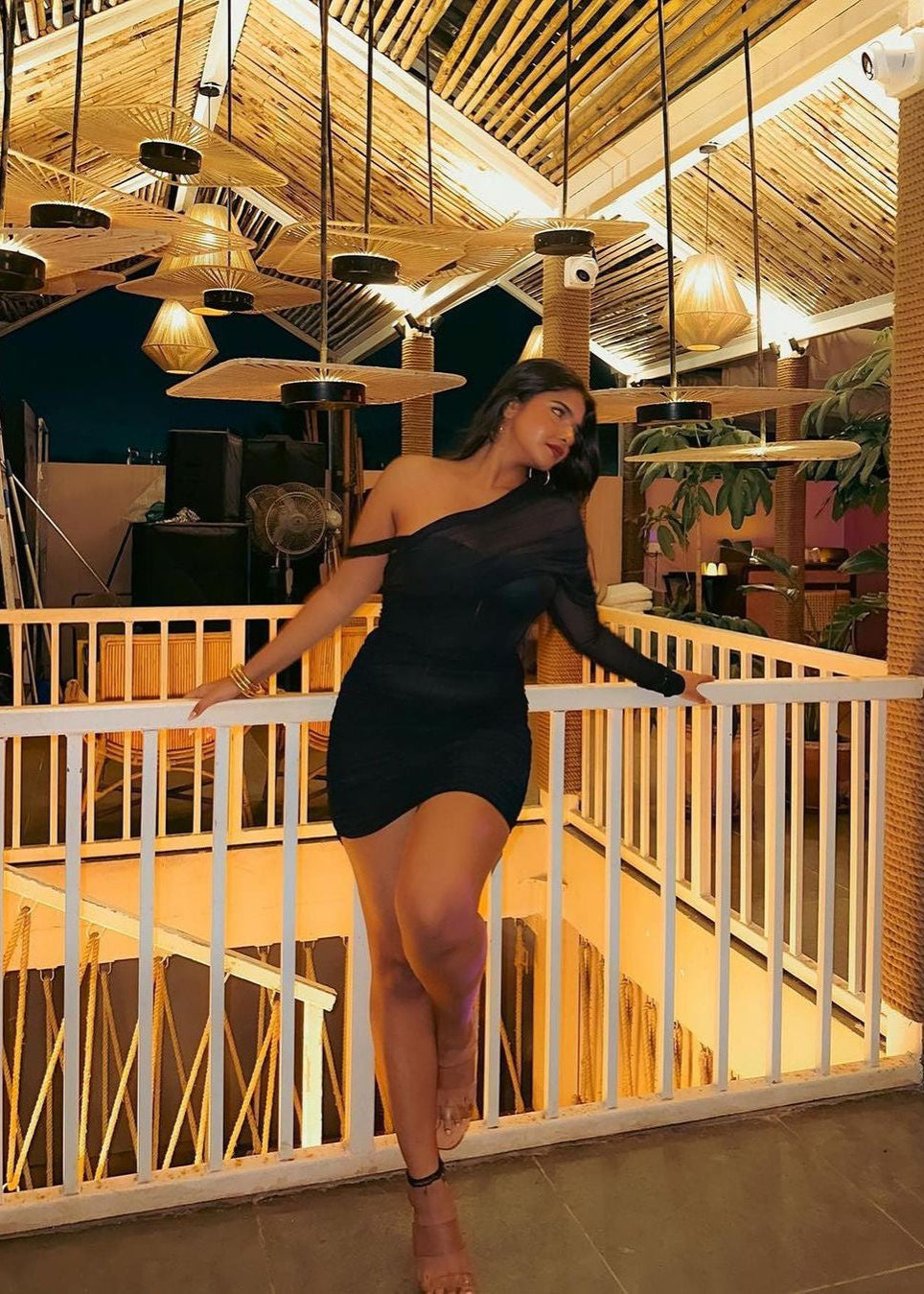 Stylish woman in a Gretchen Black Ruched Mesh Corset Dress, exuding modern sophistication