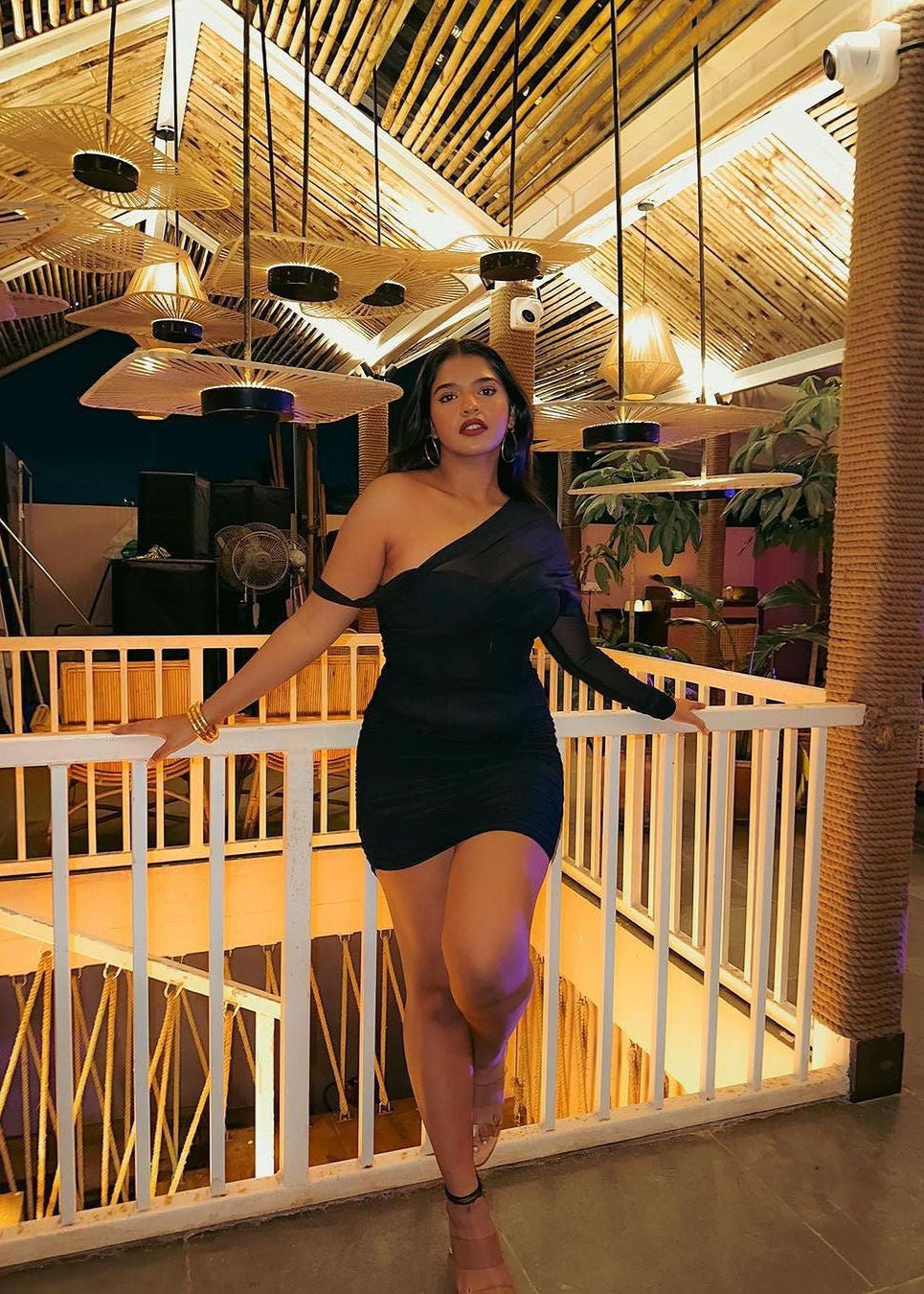 Stylish woman in a Gretchen Black Ruched Mesh Corset Dress, exuding modern sophistication