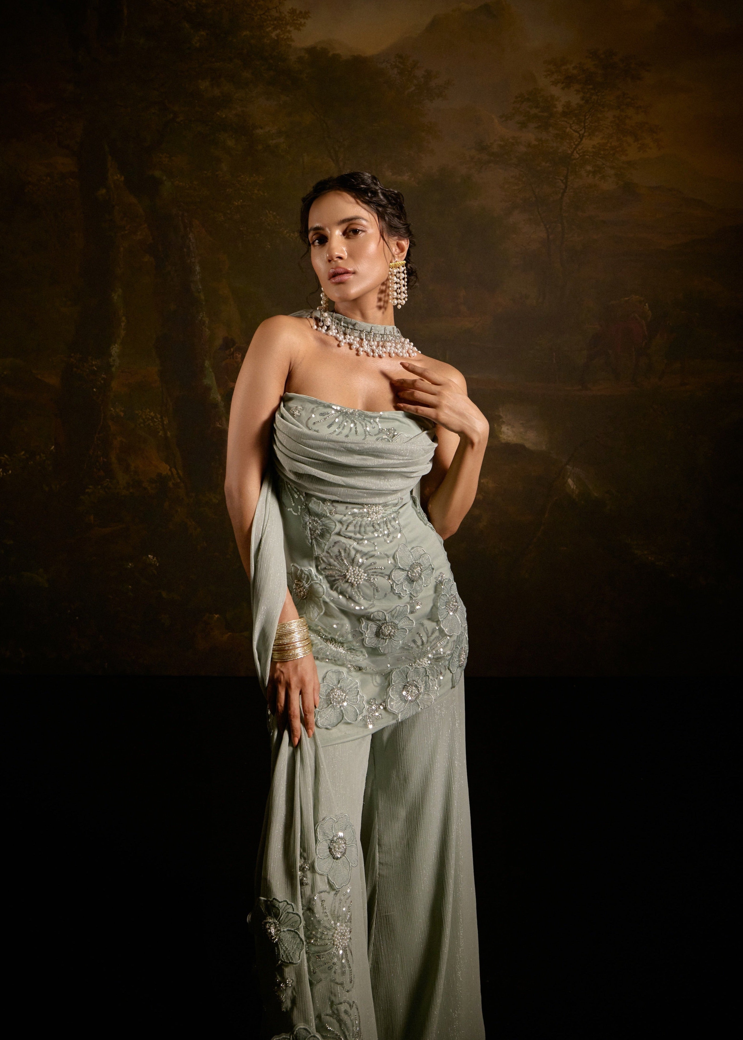 "Nakhat Sage Green 3D Flower Embroidered Sleeveless Sharara Set: Stylish sleeveless sharara set in sage green, adorned with intricate 3D flower embroidery for a unique and elegant look."