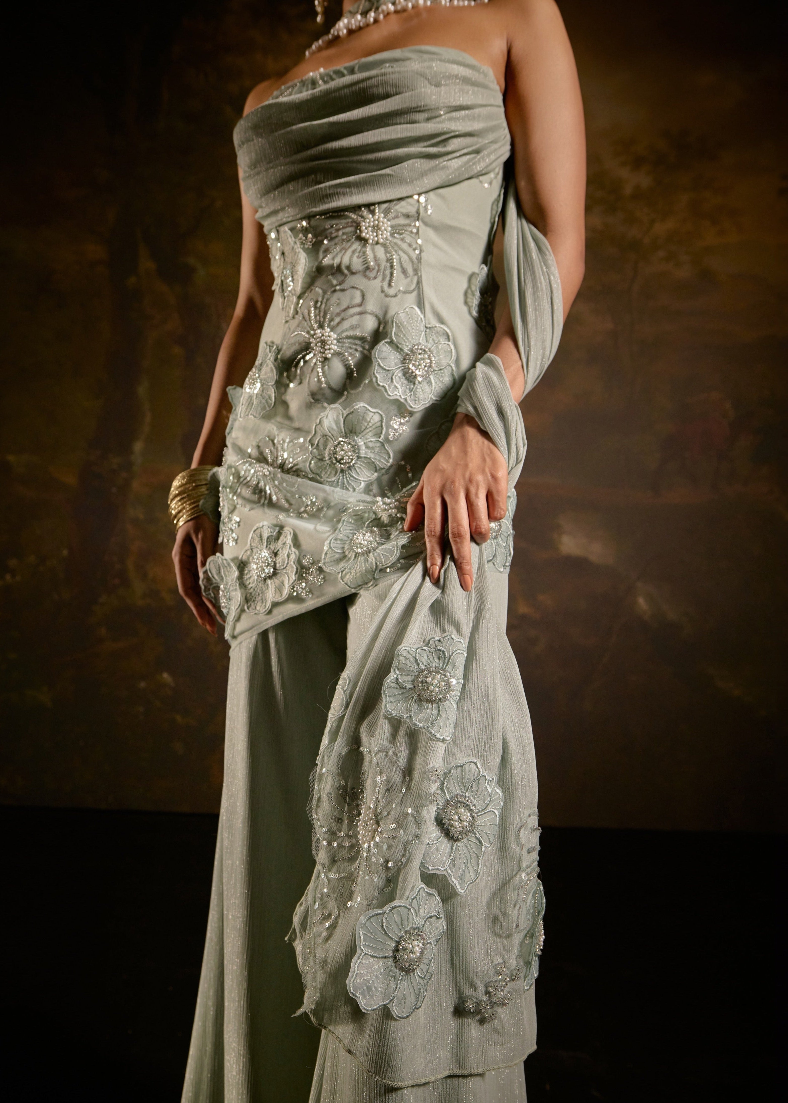 "Nakhat Sage Green 3D Flower Embroidered Sleeveless Sharara Set: Stylish sleeveless sharara set in sage green, adorned with intricate 3D flower embroidery for a unique and elegant look."