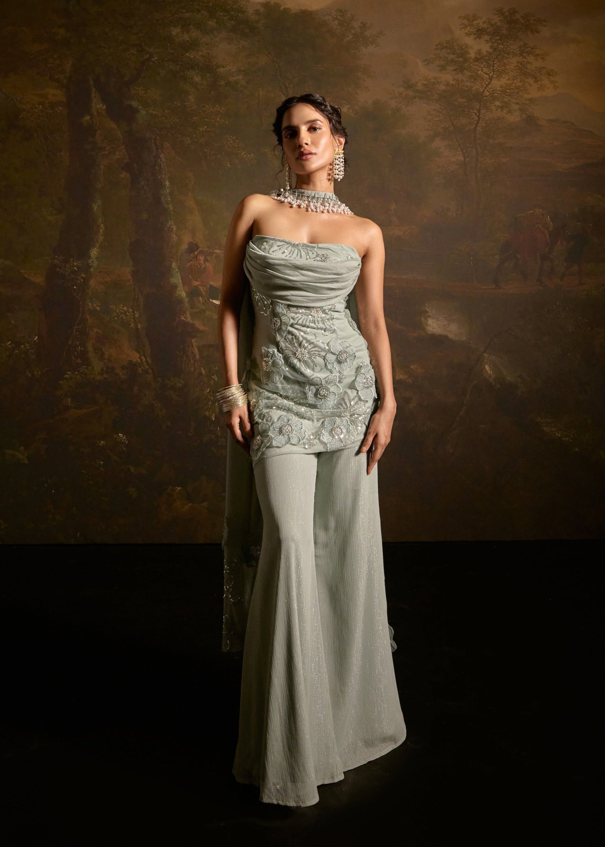 "Nakhat Sage Green 3D Flower Embroidered Sleeveless Sharara Set: Stylish sleeveless sharara set in sage green, adorned with intricate 3D flower embroidery for a unique and elegant look."