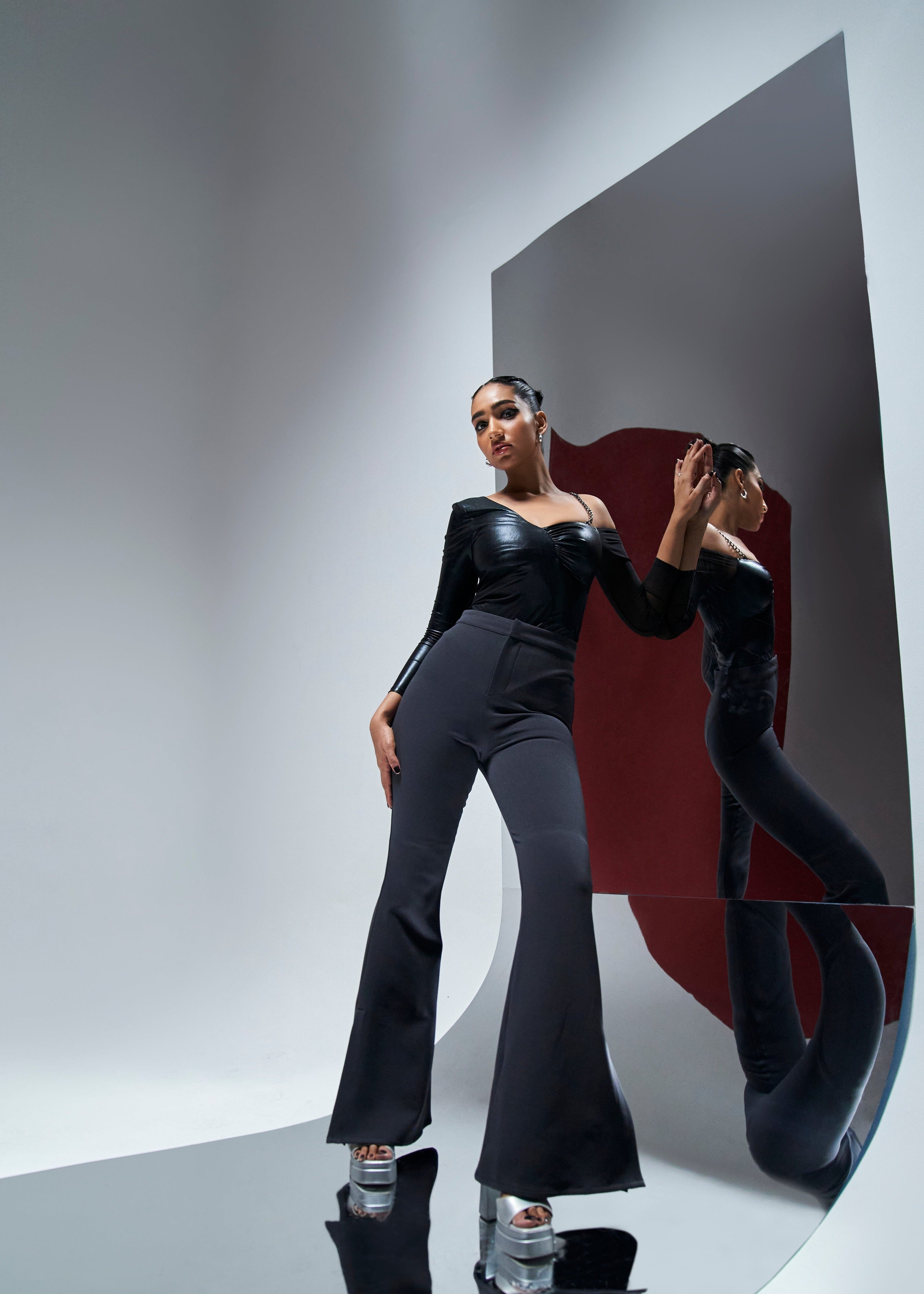 Nicolette coord set featuring a black shine bodysuit and grey flare slit pants for a chic and edgy look