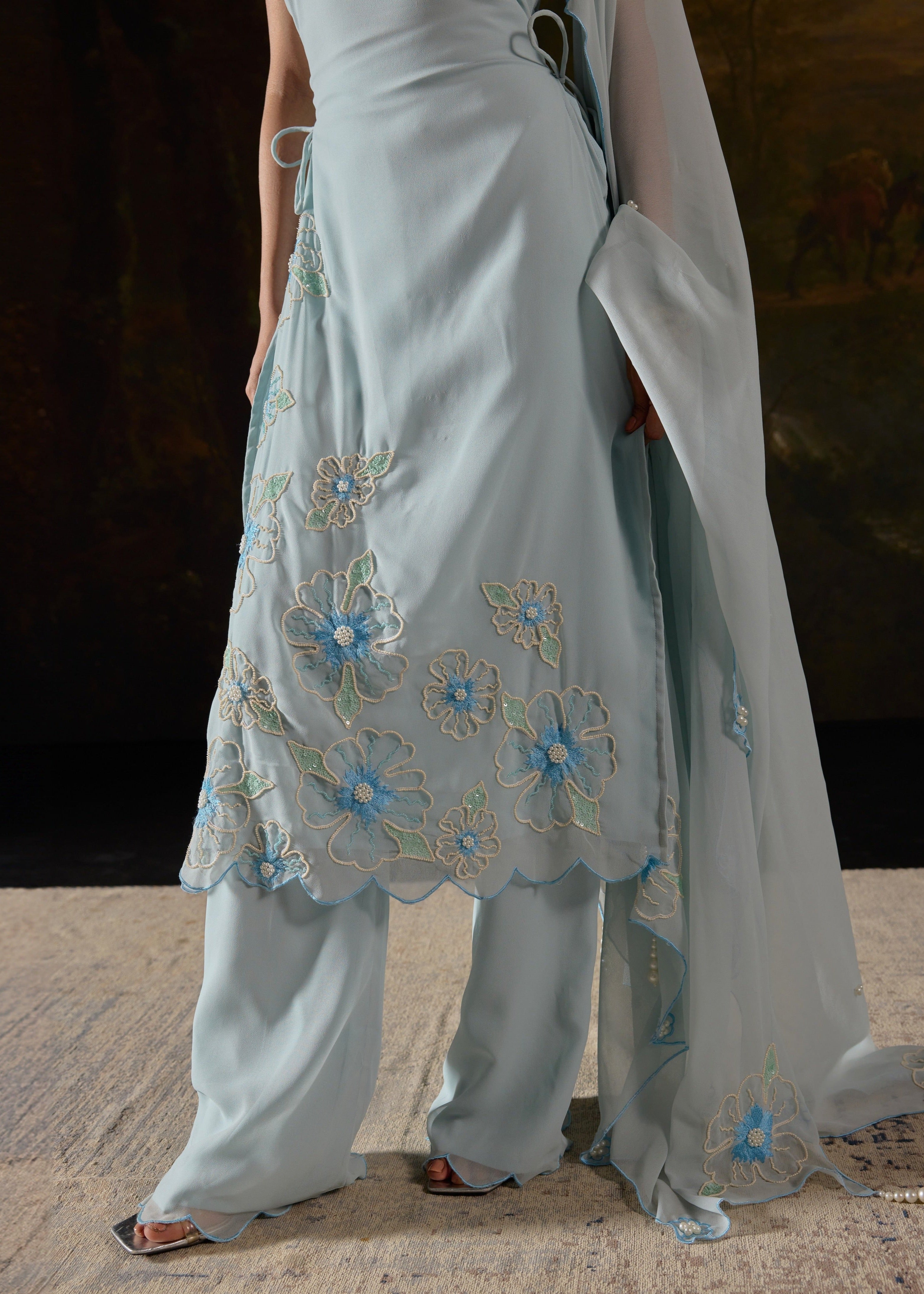 Raaya Baby Blue Hand-Embroidered Sleeveless Suit featuring intricate floral designs and lightweight fabric."
