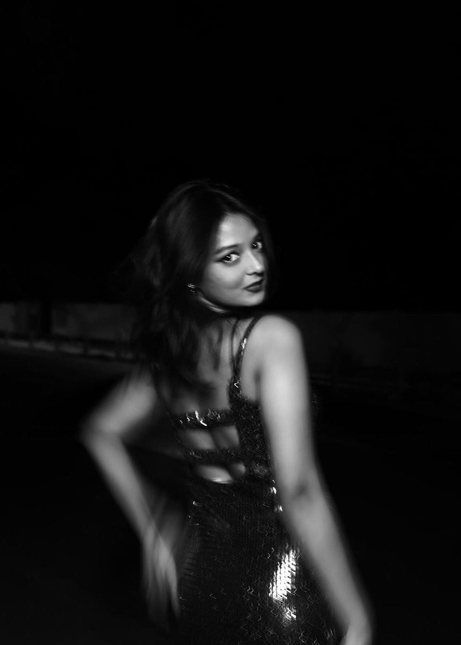 Santana Black Shine Cutout Gown: A sleek black gown with shiny fabric and intricate cutouts, perfect for a glamorous and sophisticated evening look.