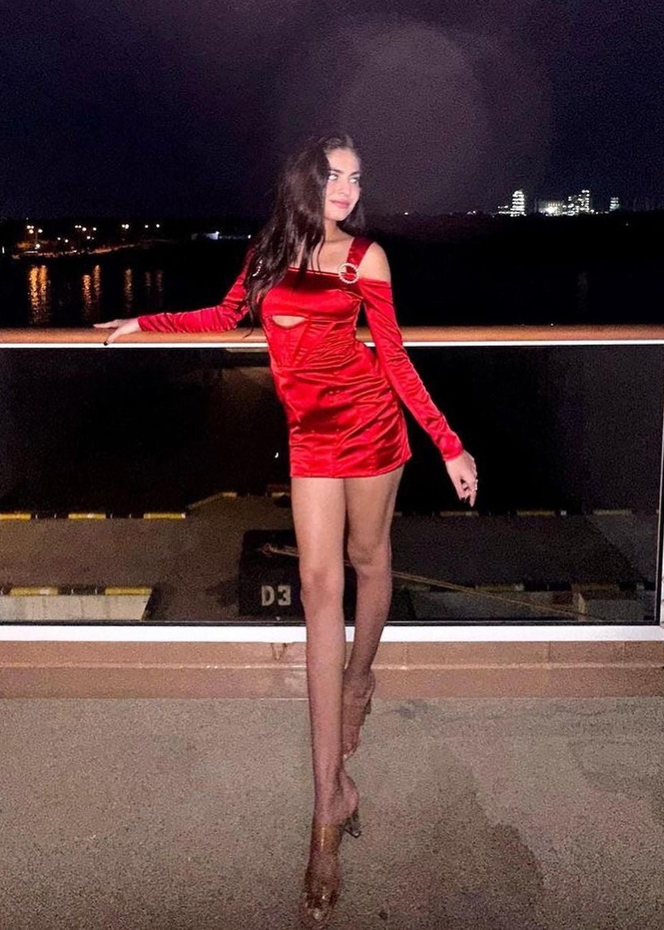 Stylish woman in a Sofia Red Stretch Satin Corset Mini Dress, exuding bold elegance