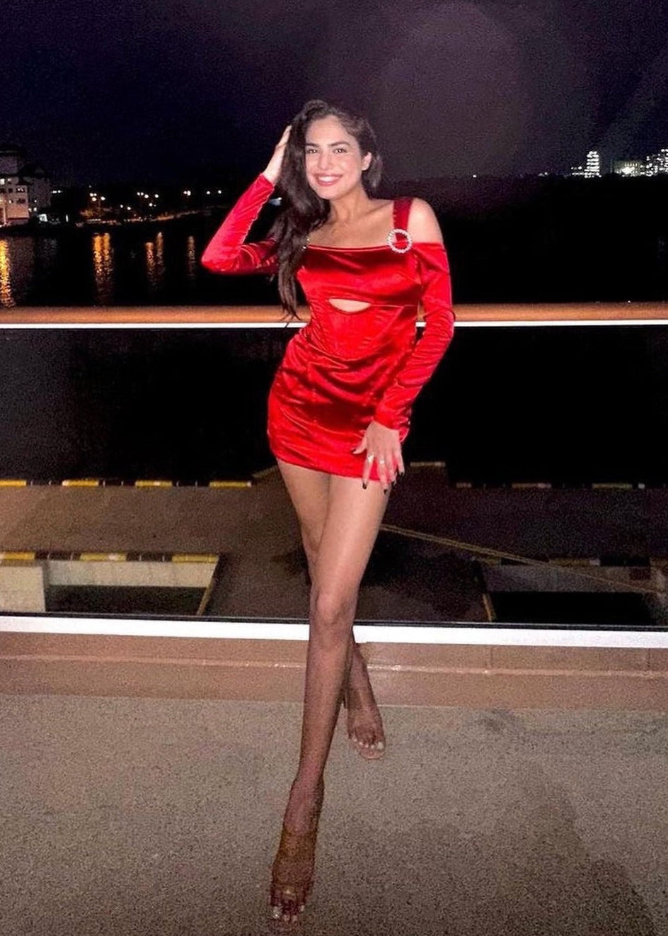 Stylish woman in a Sofia Red Stretch Satin Corset Mini Dress, exuding bold elegance