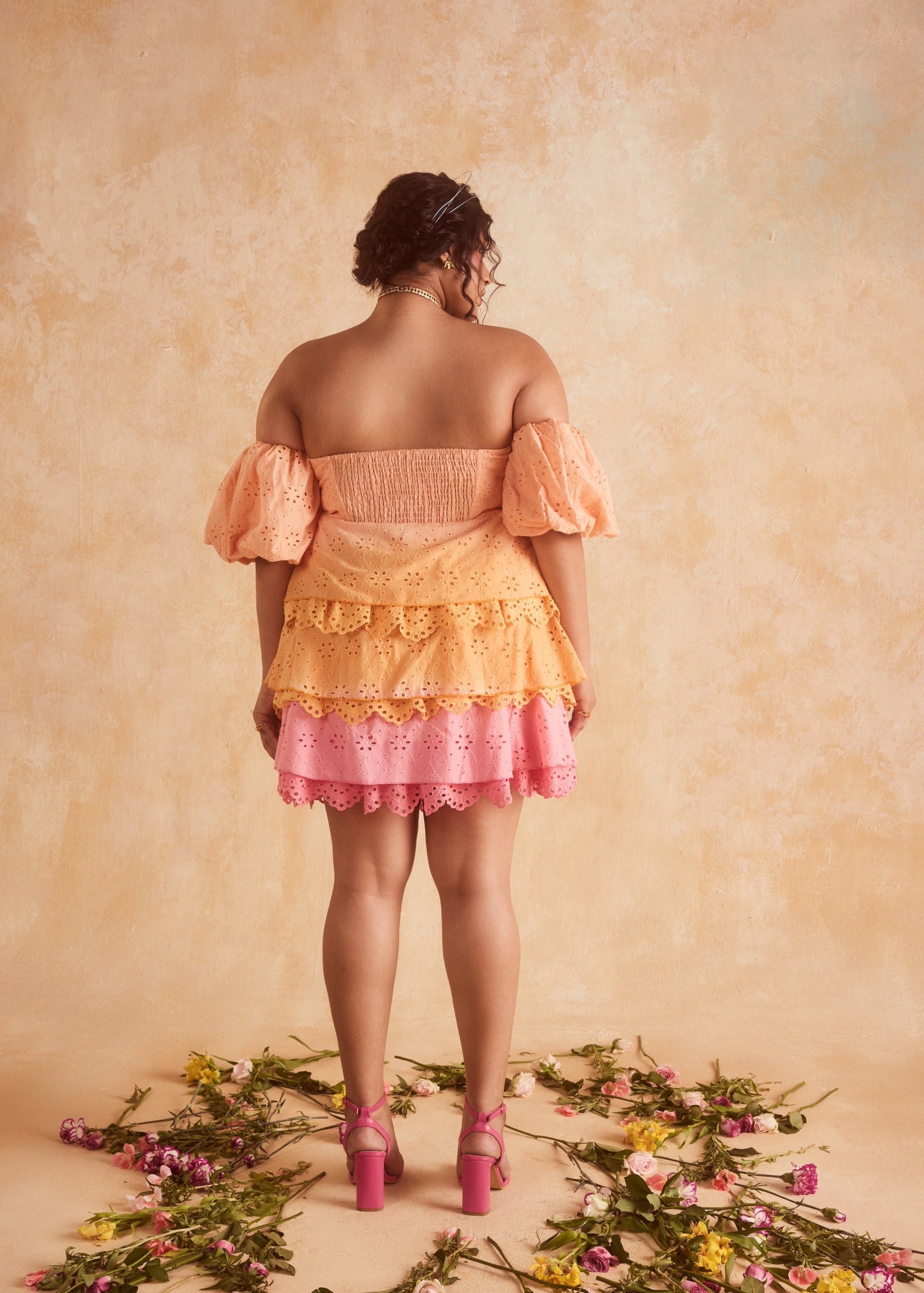 Stevie Sunset Ombre Schiffli Ruffled Corset Mini Dress, featuring a gradient sunset ombre design with Schiffli embroidery and ruffled details.