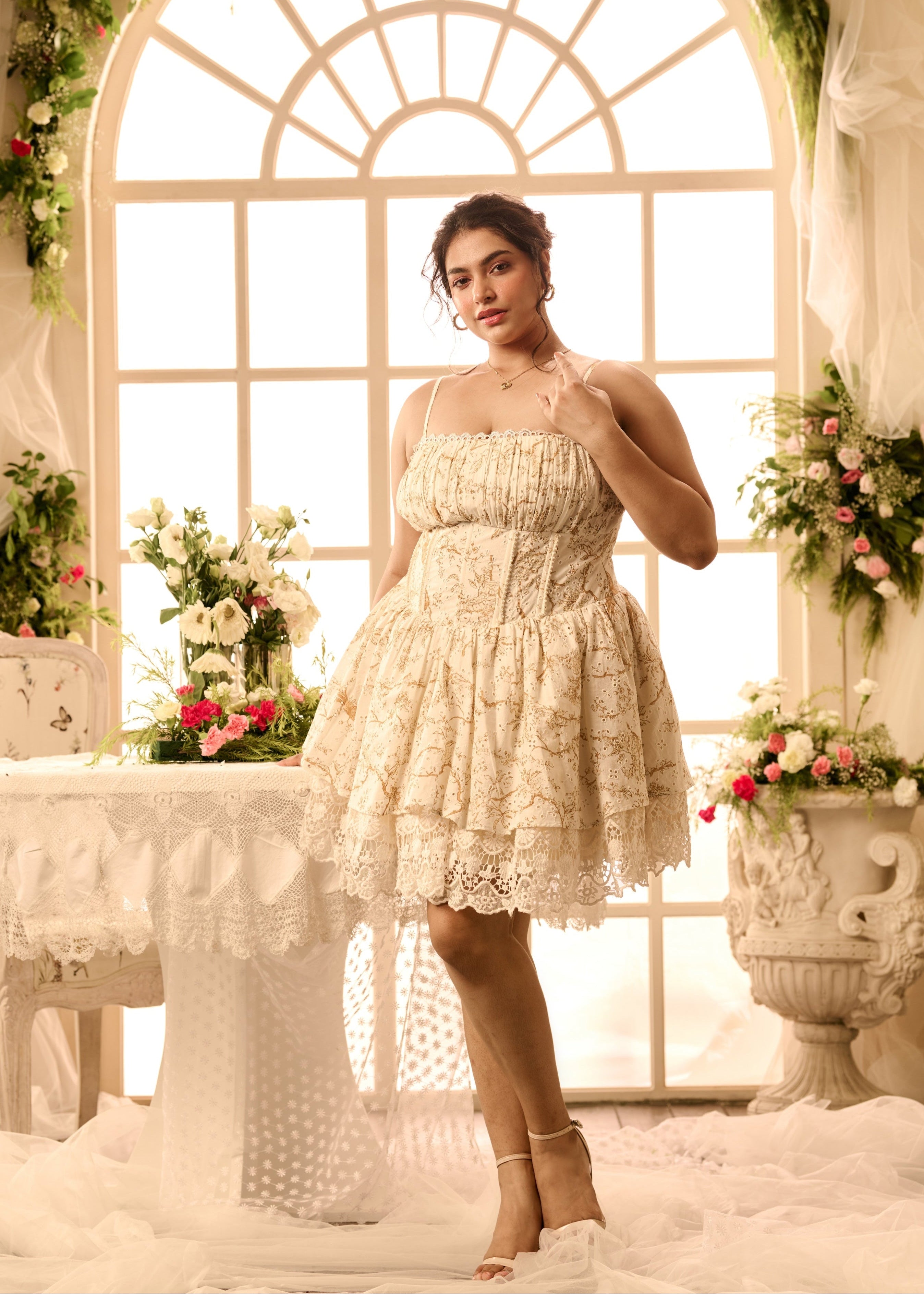 A white mini dress with golden print and lace detailing