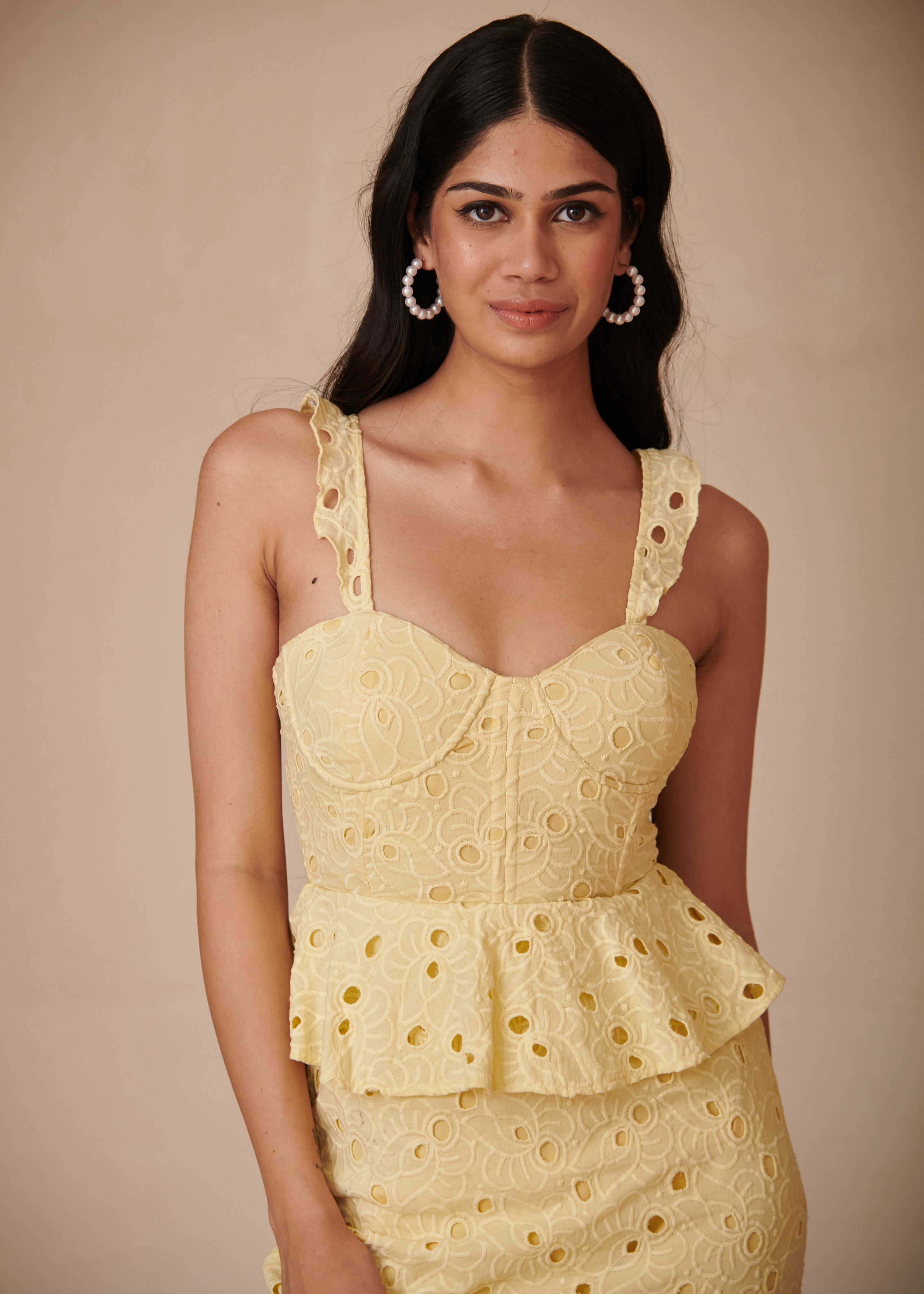 Elegant woman in a Mika Yellow Embroidered Schiffli Corset Midi Dress, radiating sunshine and charm