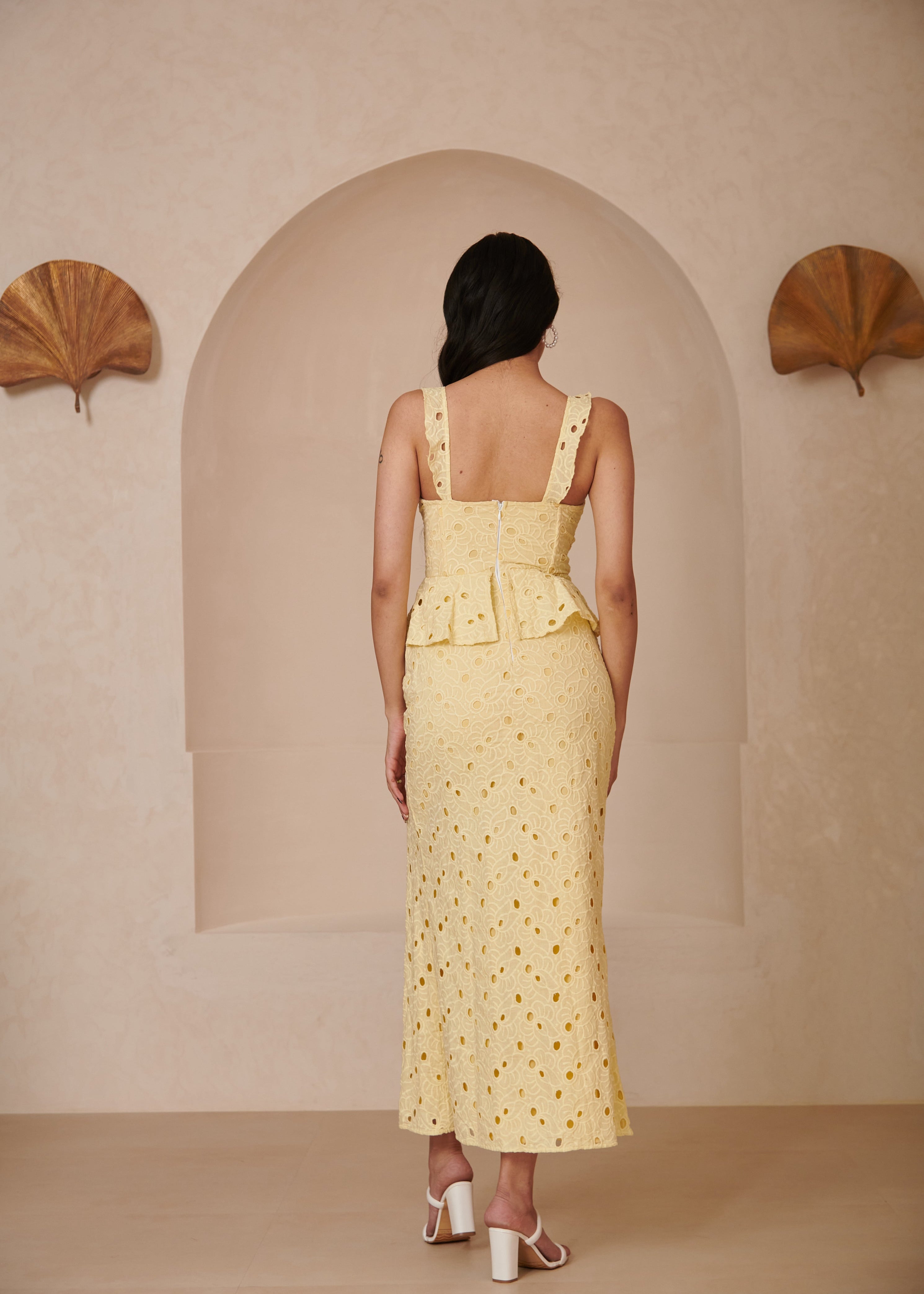 Elegant woman in a Mika Yellow Embroidered Schiffli Corset Midi Dress, radiating sunshine and charm