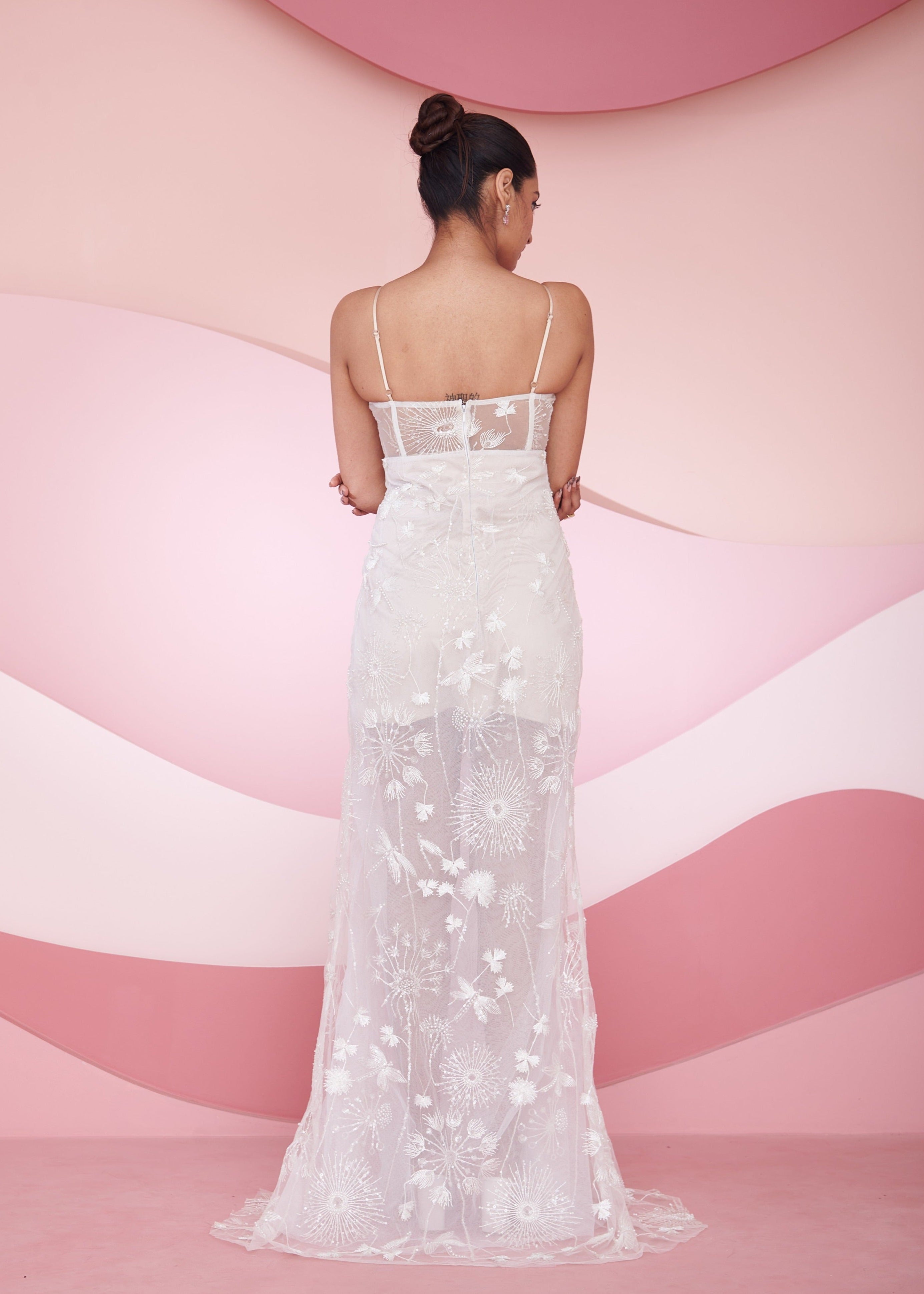 Nira white embroidered slit corset gown with intricate embroidery, a daring slit, and a fitted corset bodice, ideal for sophisticated occasions.